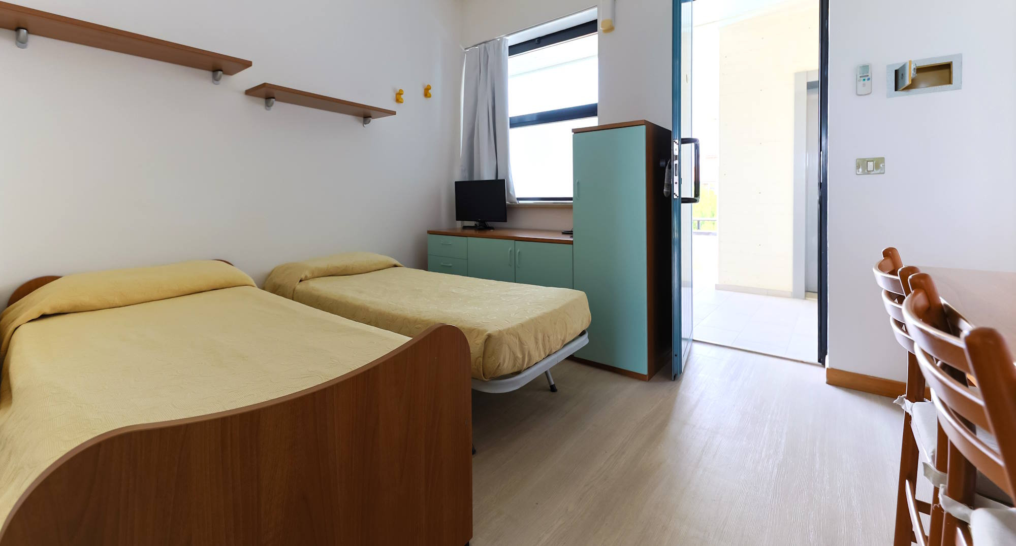 media.Appartamenti bilocali per vacanze ingresso soggiorno con letto a cassettone Club Family Hotel Residence Costa dei Pini Pinarella di Cervia
